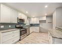 Modern kitchen with stainless steel appliances, white cabinets, and marble counter tops at 12289 W Dakota Dr, Lakewood, CO 80228
