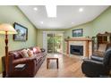 Bright living room featuring hardwood floors, fireplace, and sliding glass doors to a balcony at 8225 Fairmount Dr # 10-203, Denver, CO 80247
