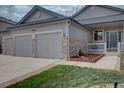 Close-up of a home with a three-car garage featuring stone accents, enhancing the home's curb appeal at 16397 Sheridan Dr, Parker, CO 80134