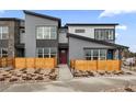 Contemporary townhome featuring gray siding, wood fence, and a red front door at 9445 W 58Th Cir # C, Arvada, CO 80002