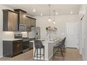 Modern kitchen featuring stainless appliances, island with seating, and stylish pendant lighting at 9445 W 58Th Cir # C, Arvada, CO 80002