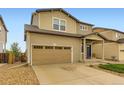 Two-story home featuring a two-car garage, blue door, and well-maintained front yard with rock landscaping at 1998 Coach House Loop, Castle Rock, CO 80109