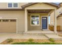 Home exterior showcasing a two-car garage and a welcoming blue front door with a covered porch at 1998 Coach House Loop, Castle Rock, CO 80109