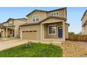 Two-story home featuring a two-car garage, blue door, and well-maintained front yard with green grass at 1998 Coach House Loop, Castle Rock, CO 80109