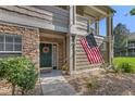 Inviting front entrance adorned with stone accents, decorative wreath, and an American flag, adding charm at 4385 S Balsam St # 10-103, Littleton, CO 80123
