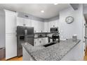 Bright kitchen boasts granite countertops, stainless appliances, and white cabinets at 4385 S Balsam St # 10-103, Littleton, CO 80123