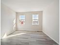 Bright bedroom featuring large windows and stylish light wood flooring at 660 Apex Rise St, Erie, CO 80516