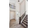 Bright foyer with high ceilings, features a staircase with wood banister and light wood flooring at 660 Apex Rise St, Erie, CO 80516