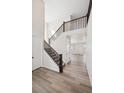 Bright open foyer featuring a staircase with wood banister, and lovely light wood flooring at 660 Apex Rise St, Erie, CO 80516