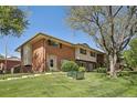 Charming townhome with red brick, neutral siding, and well-maintained front lawn and landscaping at 12455 W Alameda Dr, Lakewood, CO 80228