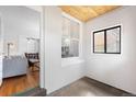 Bright entry area with a white brick wall, and a view into the living room at 178 W Cedar Ave, Denver, CO 80223