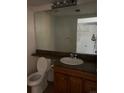 Bathroom featuring a large mirror, wood vanity, and a view into an adjoining storage room at 4296 S Halifax Way, Aurora, CO 80013