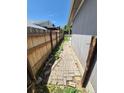 Narrow side yard with a brick path and a wooden fence, offering potential for landscaping at 4296 S Halifax Way, Aurora, CO 80013