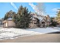 Two-story home with stone accents and a snow-covered front yard at 6386 E Tufts Ave, Englewood, CO 80111