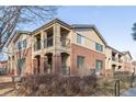 Exterior view showcases the brick facade, balconies, and well-kept grounds of this two-story townhome at 290 Poplar St # A, Denver, CO 80220