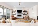 Cozy living room with a fireplace, TV, shelving, and comfortable armchairs and couch at 22364 E Bailey Pl, Aurora, CO 80016