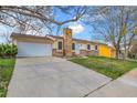 Charming home featuring a stone chimney and a large driveway, providing ample parking space at 11203 W Dorado Ave, Littleton, CO 80127