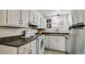 Efficient kitchen with white cabinetry, stainless steel refrigerator and modern sink area at 1525 S Holly St # 106, Denver, CO 80222