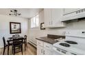 Compact kitchen features white cabinets, a dining table, and plenty of natural light at 1525 S Holly St # 106, Denver, CO 80222