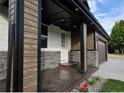 Covered entryway with stone accents, wood-look siding and decorative black support columns at 5550 Wetlands Dr, Longmont, CO 80504