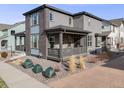A covered back porch with seating offers outdoor relaxation in this home's cozy backyard setting at 9694 Meeker St, Littleton, CO 80125