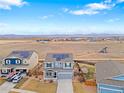 Expansive aerial view of a home with solar panels, neighboring houses, and vast open fields in the distance at 7131 Shavano Cir, Frederick, CO 80504