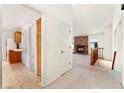Bright interior featuring an open floor plan, brick fireplace, staircase, and easy access to the kitchen at 6929 E Briarwood Dr, Centennial, CO 80112
