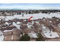 Aerial view of townhome community with snow-covered landscape and mountain views at 9875 Greensview Cir, Lone Tree, CO 80124