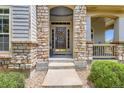 Inviting front door with stone surround and seasonal wreath, creating a warm welcome at 11638 Xavier Way, Westminster, CO 80031