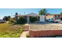 Brick home with a landscaped front yard, steps leading to the entrance, and a stone retaining wall at 7609 Sherman Pl, Denver, CO 80221