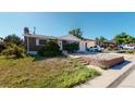 House exterior showcasing a brick facade, driveway, and well-maintained lawn at 7609 Sherman Pl, Denver, CO 80221