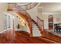 Stunning foyer with wood floors, a curved staircase, and an abundance of natural light at 26656 E Peakview Dr, Aurora, CO 80016