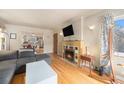 Living room featuring hardwood floors, a fireplace, and an open view into the adjacent kitchen area at 3905 E 2Nd Ave # 2, Denver, CO 80206