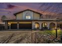 Two-story home showing a two-car garage, front porch arches, and beautiful landscaping at sunset at 1482 S Lansing St, Aurora, CO 80012