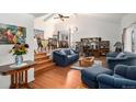 Cozy living room with hardwood floors, vaulted ceiling, and access to dining area at 1482 S Lansing St, Aurora, CO 80012
