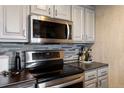 Updated kitchen featuring stainless steel appliances, gray cabinets, and stylish backsplash at 12762 Ironstone Way # 302, Parker, CO 80134