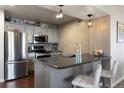 Modern kitchen with gray cabinets, stainless steel appliances, and an island with bar seating at 12762 Ironstone Way # 302, Parker, CO 80134