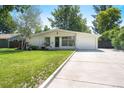 Traditional single-story home features a clean and modern design with a long driveway at 1360 S Hudson St, Denver, CO 80222
