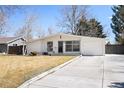 Well-maintained single-story house with a white exterior, attached garage, and long driveway at 1360 S Hudson St, Denver, CO 80222