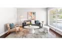 Stylish living room featuring a modern aesthetic with natural light through a large window at 1360 S Hudson St, Denver, CO 80222