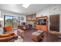 This living room is fitted with a brick fireplace, plush seating, and sliding glass doors to the outside at 10150 E Virginia Ave # 11-202, Denver, CO 80247