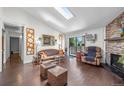 Cozy living room featuring vaulted ceilings, a skylight, and a brick fireplace at 10150 E Virginia Ave # 11-202, Denver, CO 80247