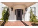 Beautiful front door with decorative glass and sidelights, framed by brick and greenery at 2 Sterling Ave, Cherry Hills Village, CO 80113
