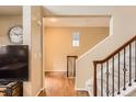 Inviting home entryway featuring hardwood floors, staircase with carpet runner, and neutral wall color at 9470 Loggia St # D, Highlands Ranch, CO 80126