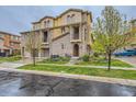 Attractive multi-story townhouse featuring stone accents, private balconies, and a well-maintained lawn at 9470 Loggia St # D, Highlands Ranch, CO 80126