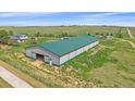 Exterior shot of the barn featuring a green roof, light colored walls, and an open doorway at 9255 N Delbert Rd, Parker, CO 80138