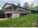 Side view showing raised home with a large deck at 5274 W Rowland Pl, Littleton, CO 80128