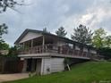 Side view showing this raised home with a large deck and basement garage at 5274 W Rowland Pl, Littleton, CO 80128
