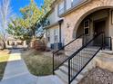Lovely townhouse features a brick archway, manicured lawn, and a welcoming entrance at 6725 S Winnipeg Cir # 106, Aurora, CO 80016