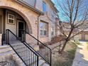 Charming townhouse showcasing a brick archway, black railing, and a well-maintained landscaped entrance at 6725 S Winnipeg Cir # 106, Aurora, CO 80016